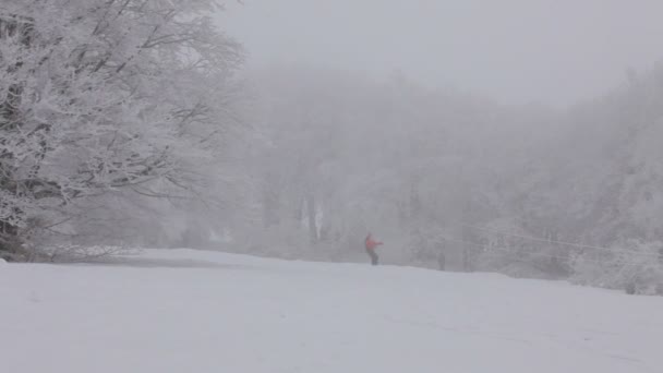 Extremalna jazda na snowboardzie. snowboardzista jadąc w dół wzgórza z mgły. — Wideo stockowe