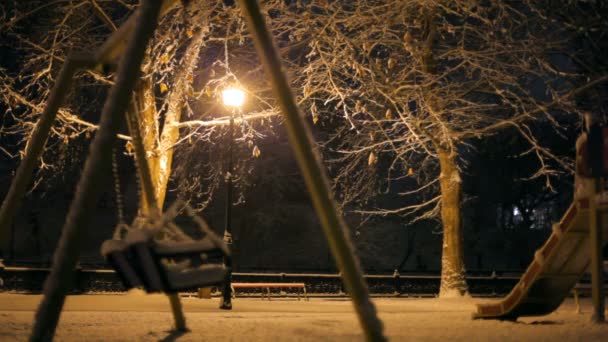 Parco giochi vuoto invernale. Parco giochi vuoto cosparso di neve . — Video Stock