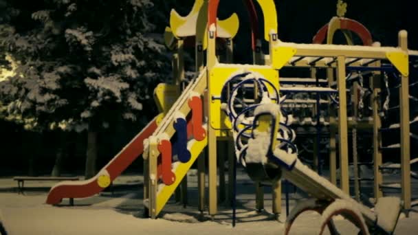 Parco giochi vuoto invernale. Parco giochi vuoto cosparso di neve . — Video Stock