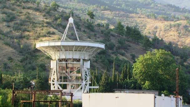 Antena satélite. Uma enorme antena parabólica é alta nas montanhas . — Vídeo de Stock