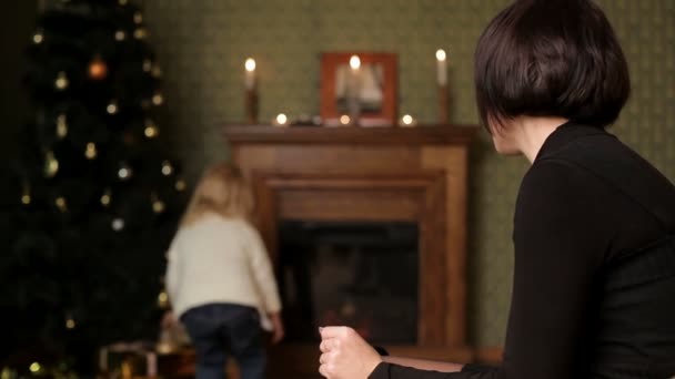 Regalo de Año Nuevo. Mamá le permite a su hija elegir algunos para los regalos de Navidad. Dos cuadros . — Vídeos de Stock