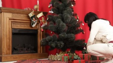 bir erkek ve bir kadın onların hediyeler Noel ağacı altında aranıyor. hediyeleri Noel ağacı altında.