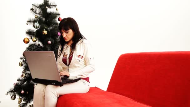 Anne üzerinde çalışan bir bilgisayar ve onunla oynamaya çalışan çocuk. bir aile Noel arifesinde. — Stok video
