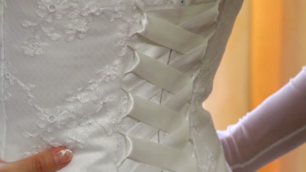 Trouwjurk. bruid kleden haar trouwjurk. bewegende camera. — Stockvideo