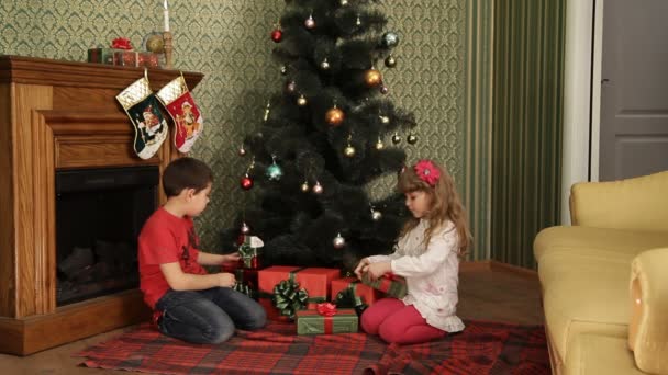 Niños bajo un árbol de Navidad — Vídeo de stock