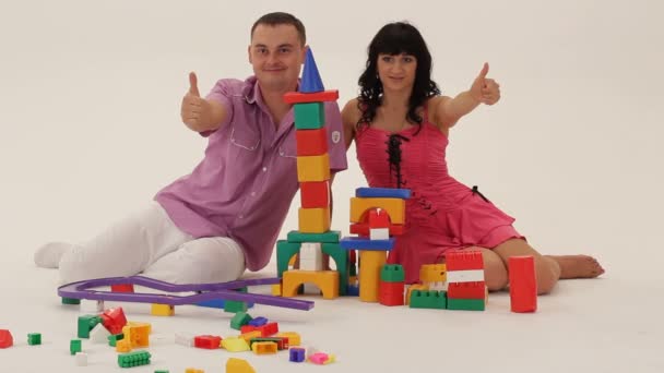 Two adults playing with toy blocks and showing thumb up — Stock Video