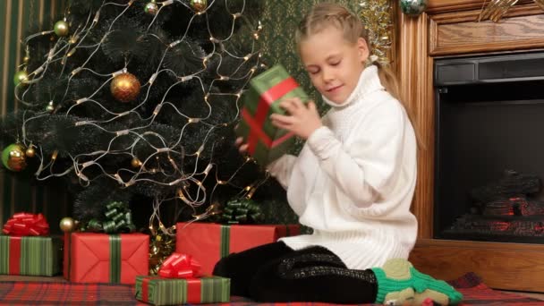 Niña eligiendo el mejor regalo bajo un árbol de Navidad. Muchos regalos. . — Vídeos de Stock