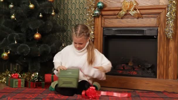 Mädchen sucht sich das beste Weihnachtsgeschenk aus. — Stockvideo