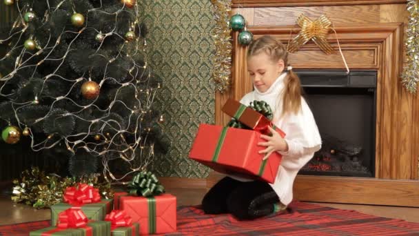 Menina escolhendo o melhor presente de Natal para si mesma . — Vídeo de Stock