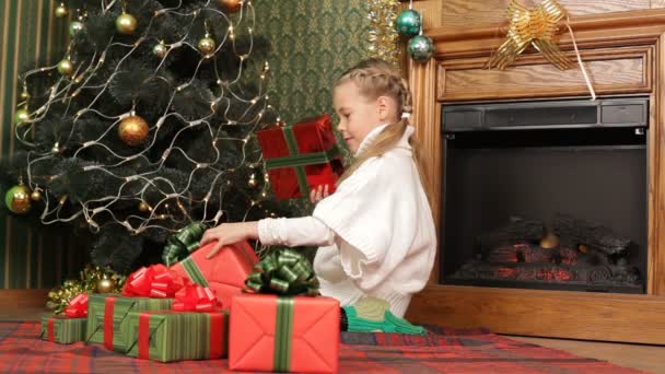 Mädchen sucht sich das beste Weihnachtsgeschenk aus. — Stockvideo
