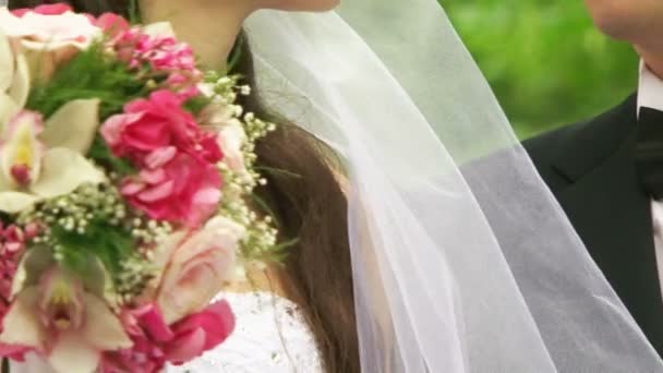 Bruid en bruidegom kussen. bruid houden een boeket — Stockvideo