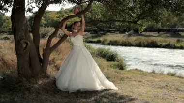 güzel bir genç kız bir ağacın altında duran bir gelinlik.