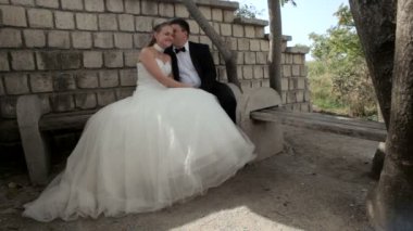 bir bankta oturan genç bir çift.