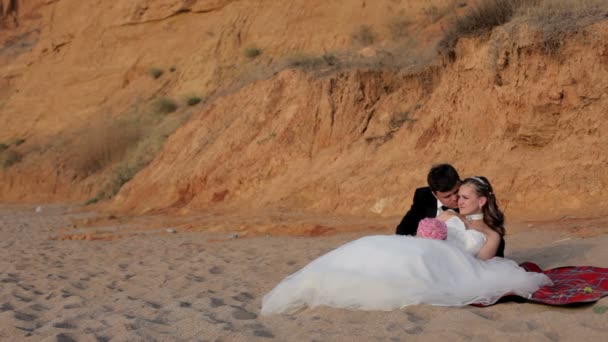 Pasgetrouwden Ontspan op het zandstrand. — Stockvideo