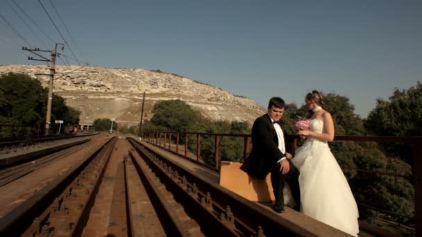 Sposi in piedi accanto alla ferrovia — Video Stock