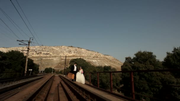 Cestování po železnici. Novomanželé jít podél zábradlí. — Stock video