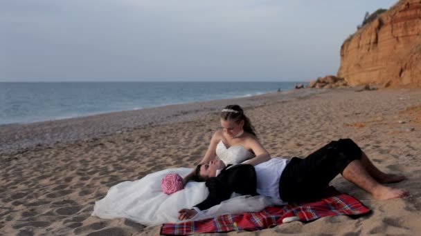 新婚夫婦は、砂浜のビーチでリラックスします。. — ストック動画