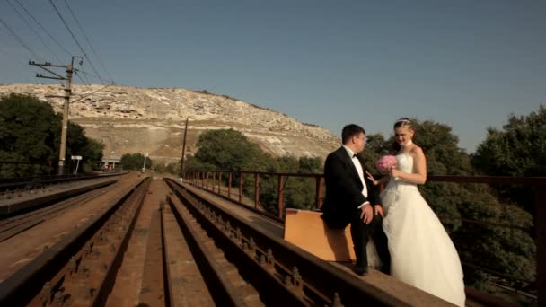 Sposi in piedi accanto alla ferrovia — Video Stock