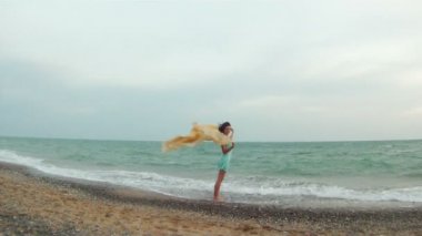 çırpınan kumaş ile bir plajda kız