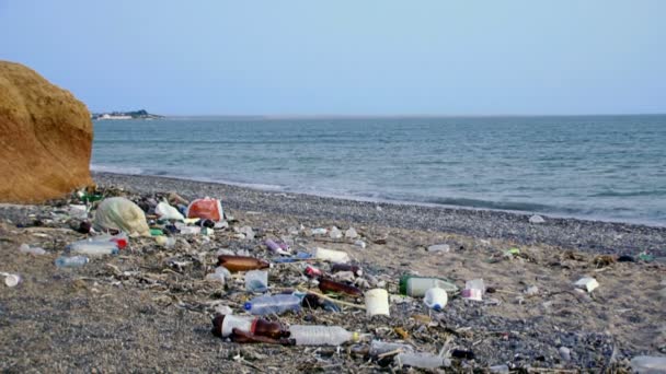 Förorening av havet. massor av skräp som ligger på stranden av den vackra havet. — Stockvideo