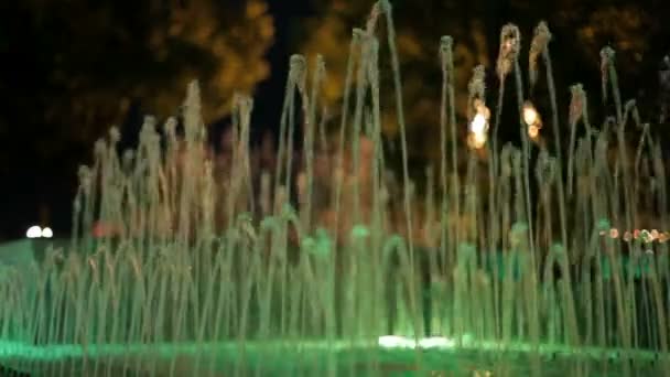 在背景中的喷泉。背光灯小喷泉与背景中的绿色自然。背景被模糊。特写. — 图库视频影像