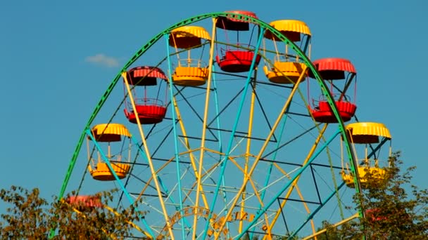 Rueda de la fortuna. Rueda de la fortuna en un parque de atracciones sobre un fondo de cielo azul . — Vídeo de stock