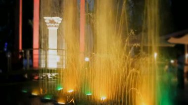 güzel dekorasyon parkta. güzel bir gece çeşme antik Yunan sütunları arka plan üzerinde renkli arka ışık ile.