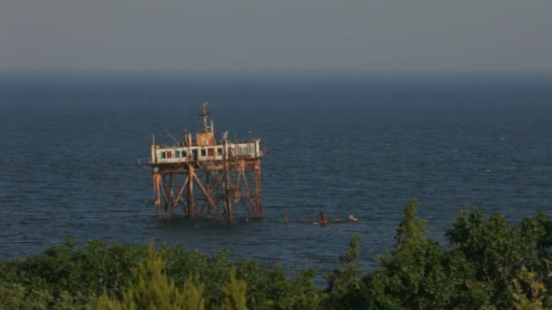 Starý rezavý stanice. Většina starých zachránci centrální věž stojí přímo v moři. — Stock video