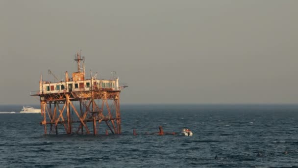 Ankor sitter på ruinerna av offshore-strukturer. i bakgrunden en rostig torn. tre ram. — Αρχείο Βίντεο