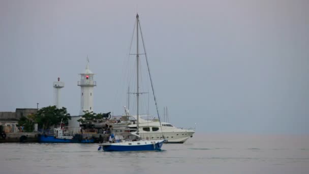 Lighthouse on the shore. Several ships off from behind the lighthouse. — Stock Video