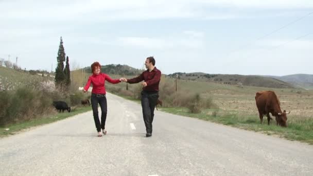 Danse le bonheur. Joyeux jeune couple dansant sur la route . — Video