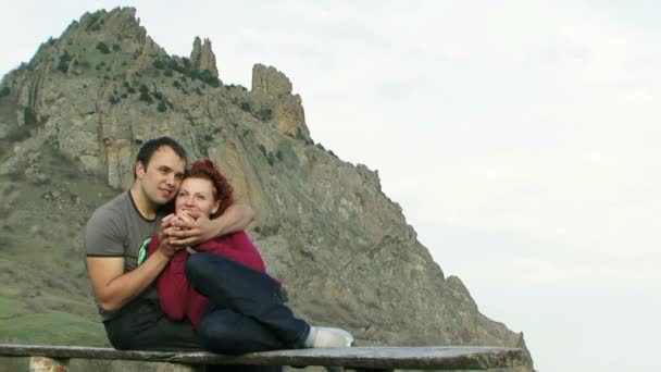 Пара сидить на відкритому повітрі. Молода пара п'є зі склянки на пляжі . — стокове відео
