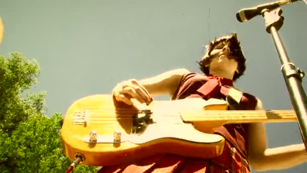 Girl plays bass guitar during an outdoor performance — Stock Video