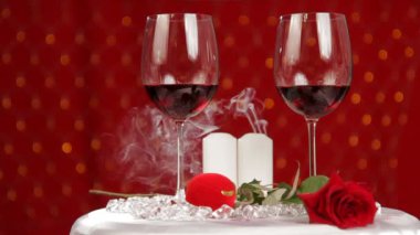 romantik bir akşam sona erdi. iki güzel kadeh şarap yanan bir mum arka plan üzerinde bulunmaktadır. sonra mum söner.