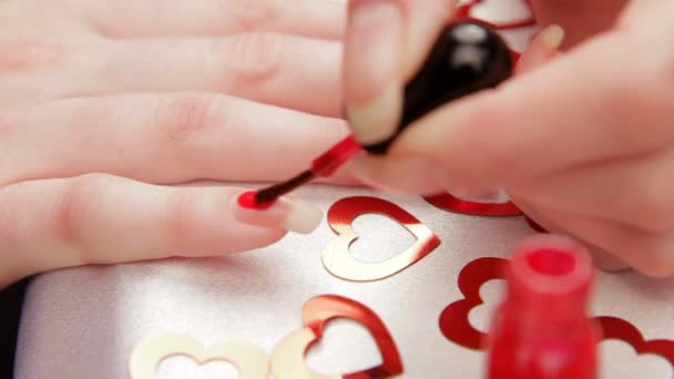 Vrouw schildert de nagels. een vrouw die zich klaar voor de dag van Valentijnskaarten. — Stockvideo