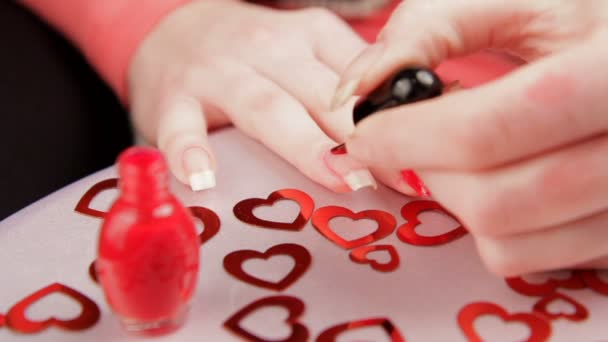 Vrouw schildert de nagels. een vrouw die zich klaar voor de dag van Valentijnskaarten. — Stockvideo