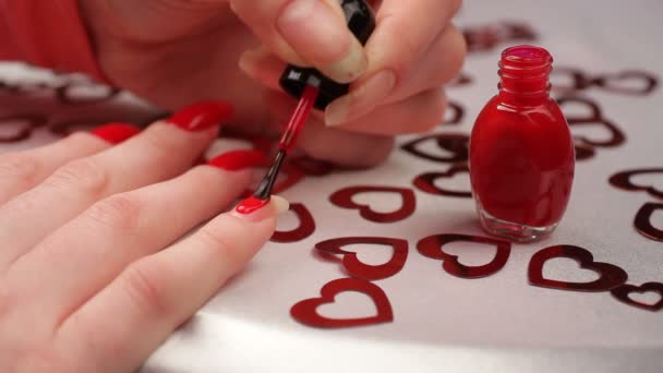 Meisje schildert haar nagels. een vrouw die zich klaar voor de dag van Valentijnskaarten. — Stockvideo