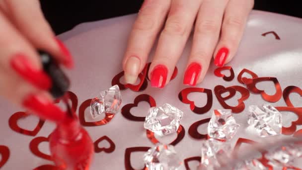 Meisje schildert haar nagels. een vrouw die zich klaar voor de dag van Valentijnskaarten. — Stockvideo