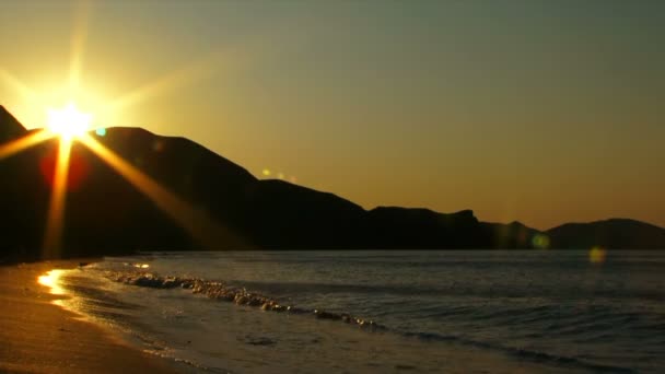 Beautiful sunset glow. Beautiful sunlit waves rolled on the sandy shore — Stock Video