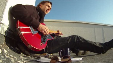 Çatıda bir gitar ile müzisyen