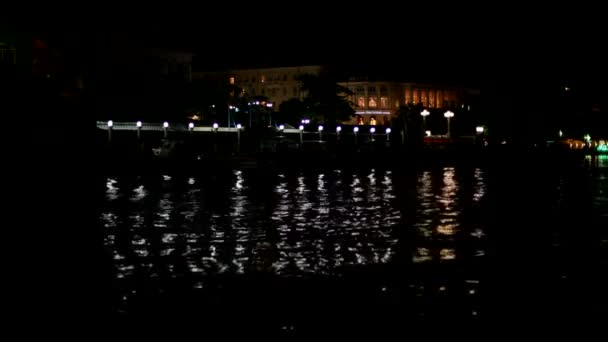 Luces de ciudad. Una hermosa ciudad nocturna en la costa . — Vídeo de stock