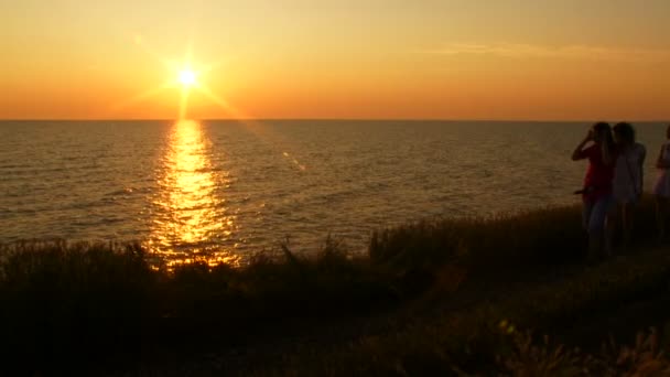 Fyra kvinnor du beundrar solnedgången. kvällssolen. — Stockvideo