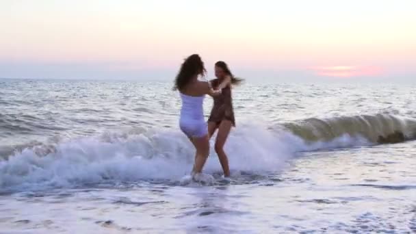 Vrienden tijd doorbrengen in de buurt van de zee bij zonsondergang — Stockvideo