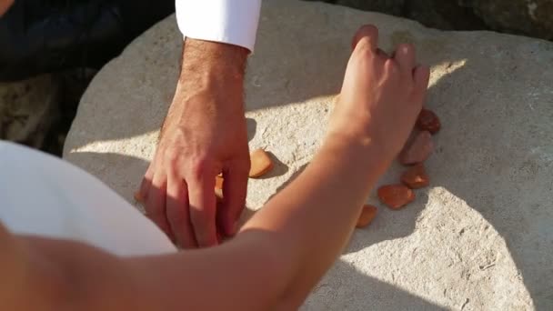 Dos formando un corazón con pequeñas rocas. Símbolo del amor . — Vídeos de Stock