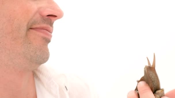 Un homme embrasse un escargot sur un fond blanc 