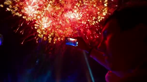 Homem filmando fogos de artifício festivos coloridos na câmera. Fogos de artifício festivos . — Vídeo de Stock
