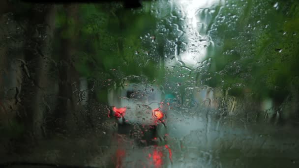 Hombre conduciendo a través de una ciudad en un día de lluvia . — Vídeos de Stock