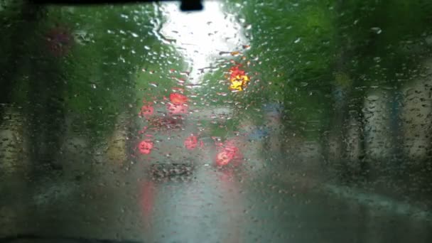 Man driving through a city on a raining day. — Stock Video