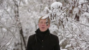 genç adam kış çam ormanı içinde şarkı