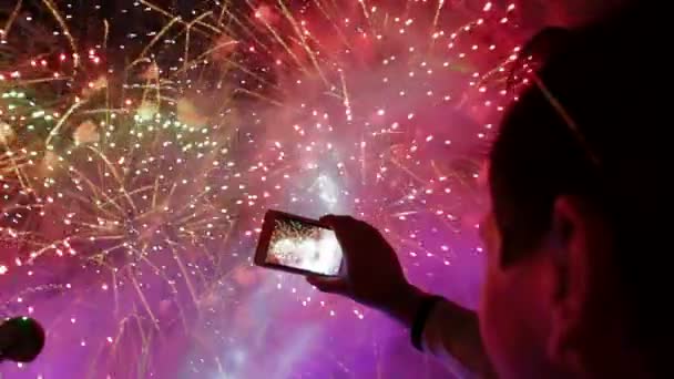 Man filmen kleurrijke feestelijke vuurwerk op camera. feestelijke vuurwerk. — Stockvideo